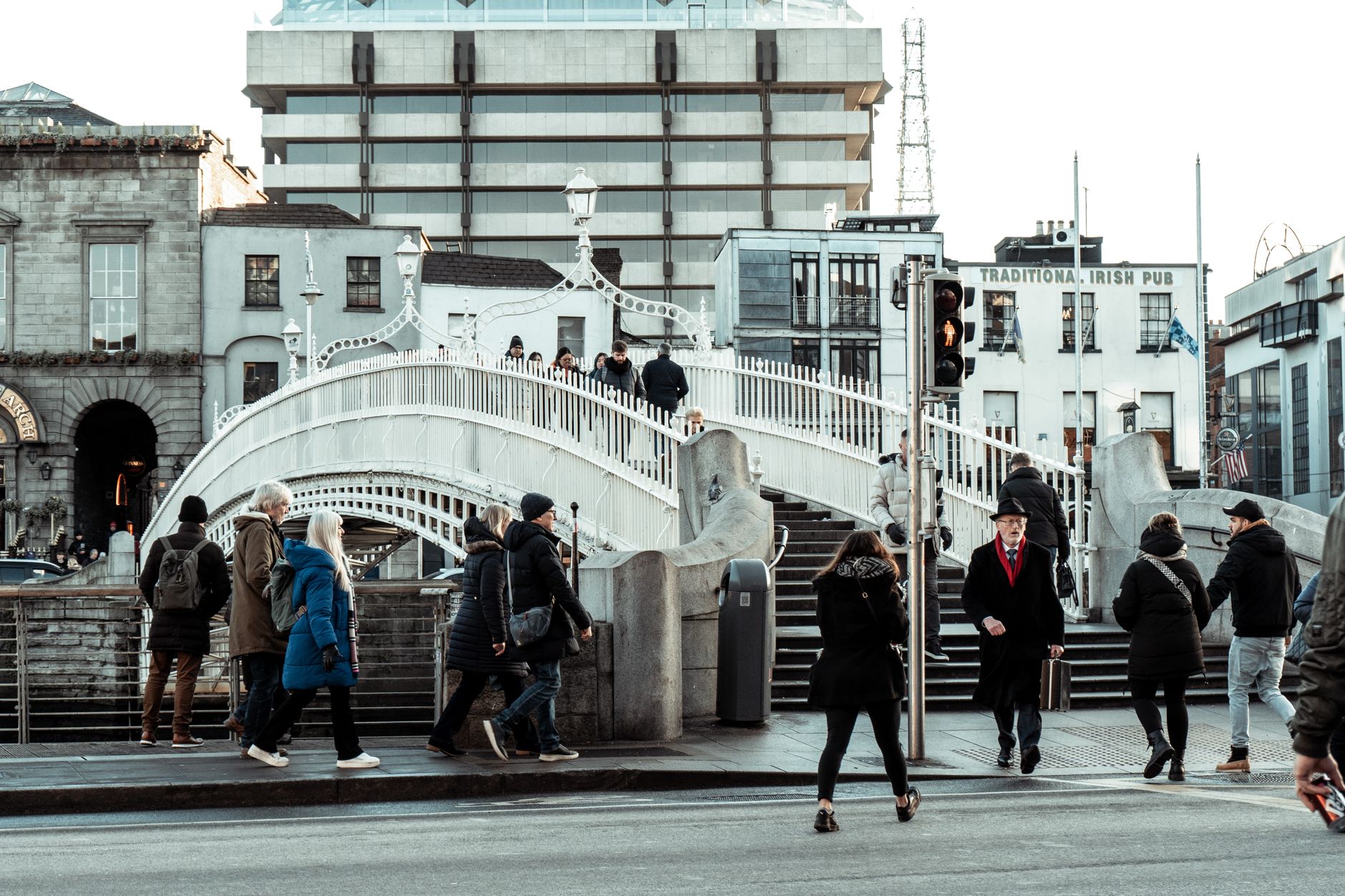 A busy Dublin street with people crossing and traffic edging forward, the everyday city a learner has to drive in