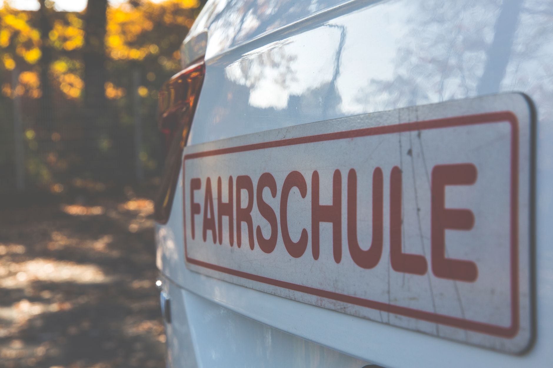 A driving-school car with a learner sign parked at the roadside, ready for a test